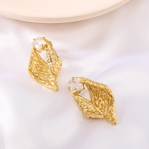 Irregular gold textured leaf earrings with square zircon stone on white silk fabric