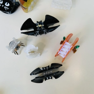 Detail shot of Halloween hair claws featuring pumpkin, ghost, and bat acrylic designs