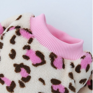 Détail d'un vêtement doux pour animaux à motif léopard avec col côtelé rose et coutures