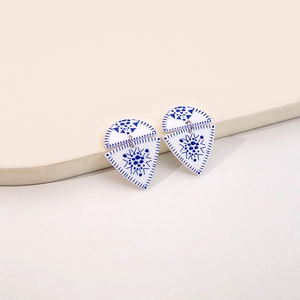 Detail of blue and white porcelain pattern earrings with geometric acrylic shapes
