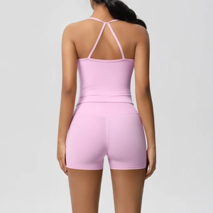 Rear view of pink two-piece yoga set featuring cross-back tank top and high-waisted shorts