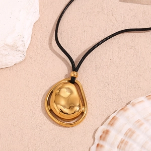 Dettaglio macro del ciondolo in pietra lavica placcato oro 18K con cordino nero minimale