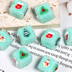 Dettaglio macro delle perline cubiche verde menta con glitter e ciondoli natalizi in resina