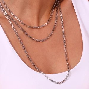 Close-up of silver layered necklace with geometric rectangular links worn on a model