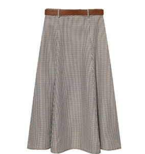 Détail de la jupe trapèze à motif pied-de-poule avec une ceinture en similicuir brun