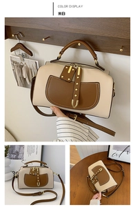 Détail du sac Boston en cuir contrasté blanc crème et marron avec ferrures dorées