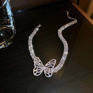 Detail of silver multilayer rhinestone choker featuring a large sparkling butterfly pendant