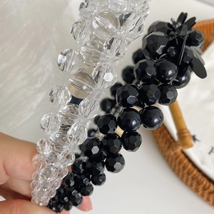 Close-up of beaded flower headband with faceted crystals and pearls in black and clear