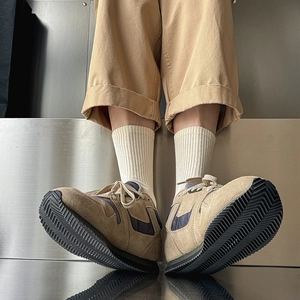 Retro khaki and navy sneakers with chunky black serrated sole worn with cargo pants