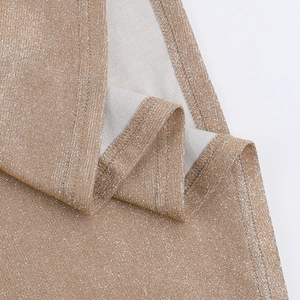 Macro detail of champagne gold shimmer fabric with high-density metallic thread and stitching