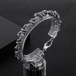 Dettaglio macro della trama a scaglie di serpente punk su bracciale in acciaio inossidabile