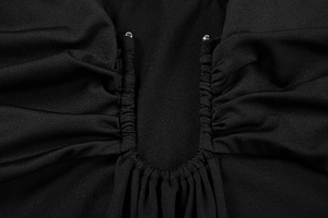 Detail of sexy black dress showing ruched fabric and U-neck with silver bead accents