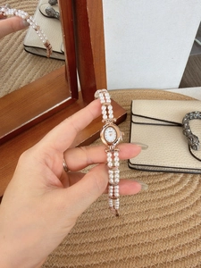 Detail of elegant vintage oval watch with mother of pearl dial and pearl bead strap