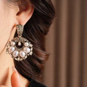 Gros plan sur des boucles d'oreilles vintage de luxe avec perles blanches et strass brillants