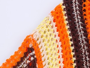 Détail macro du tissu en maille crochetée multicolore avec motif de grille orange et jaune