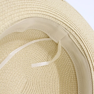 Detailed macro view of the interior straw weave and adjustable sweatband on sun hat
