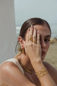 Close-up of elegant gold jewelry set with irregular rings and hammered texture bracelets