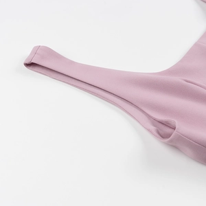 Détail de la robe plissée rose sans manches montrant les coutures et le tissu lisse