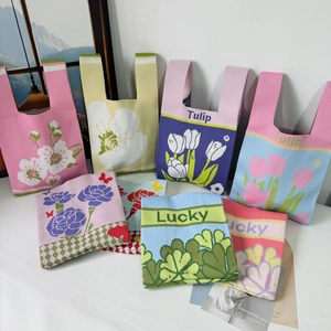 Close-up of knit tote bags with colorful floral tulip patterns and woven texture