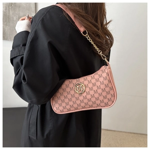 Detail of pink PU leather underarm bag with M-pattern print and gold chain strap