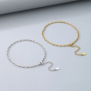 Close-up of minimalist gold and silver stainless steel chain anklets with lobster clasp