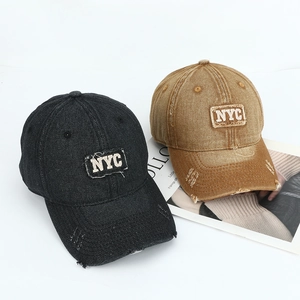 Detail of washed denim baseball caps with NYC embroidery and distressed brim details