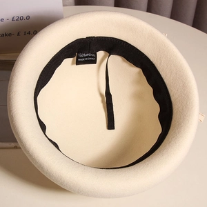 Detail view of the 100% wool beret interior with sweatband, drawstring and material label