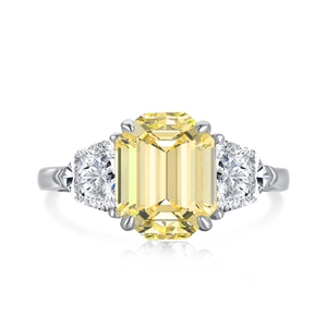 Macro shot of yellow emerald cut stone ring with side diamonds and silver band