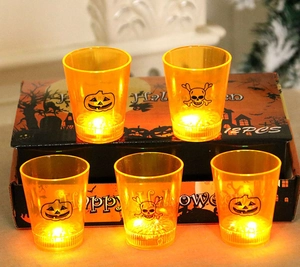 Close-up of orange Halloween LED glowing cups with pumpkin and skull prints