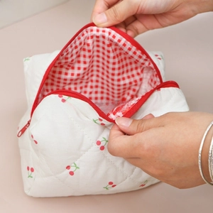 Detail showing the red gingham lining and spacious interior of the quilted cherry bag