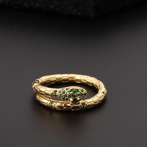 Macro view of gold-plated snake ring with green zircon eyes and scaled texture details
