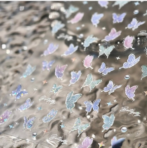 Macro shot of holographic laser butterfly nail stickers with colorful glitter effects