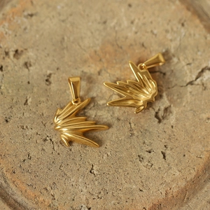 Macro detail of two golden unicorn sun pendants with a vintage textured metallic finish