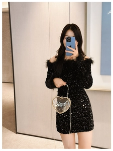 Mirror selfie showing a transparent heart-shaped acrylic bag with gold chain and handle
