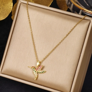 Close-up of hummingbird pendant necklace featuring colorful stones on gold chain