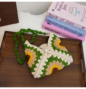 Detailed view of handmade crochet sunflower shoulder bag with pearl button and green strap