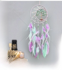 Detail of moon-shaped dream catcher with Tree of Life crystal stones and feathers