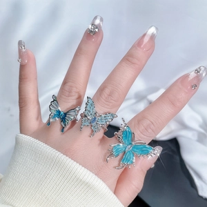Detailed macro view of silver butterfly rings with blue gradient enamel and small rhinestones