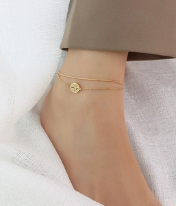 Detailed view of dual-layer titanium steel anklet with hollow round pendant on model