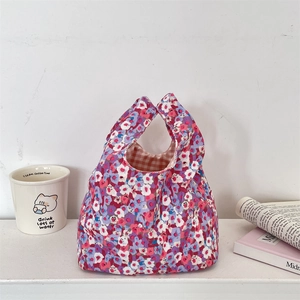 Detail of floral corduroy wrist bag with red gingham lining and soft texture
