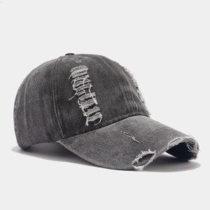 Vue détaillée de la casquette en denim délavé avec des trous vintage et des bords effilochés