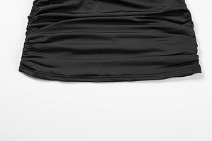 Close-up of black dress side ruching and neat hem stitching detail on elastic fabric