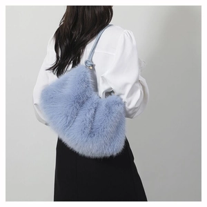 Vue détaillée d'un sac à bandoulière en peluche bleu clair porté par un mannequin de dos