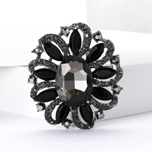 Detailed macro shot of vintage flower brooch featuring dark rhinestones and metal facets
