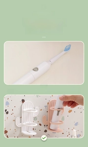 Detail of pink and white cactus wall-mounted toothbrush holders showing secure storage