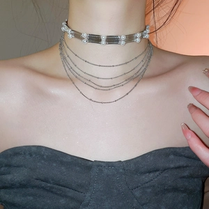 Détail du collier à plusieurs rangs avec tubes argentés, perles et chaînes fines