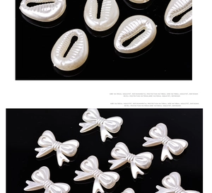 Macro detail of white pearl luster bow and shell shaped acrylic beads for DIY jewelry