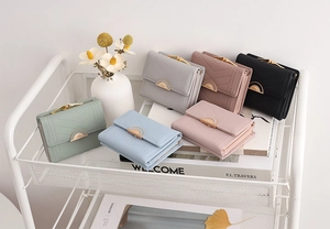 Detail of V-quilted leather mini wallets in various colors on a decorative white trolley