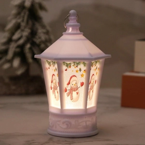 Detail of white Christmas lantern with snowman prints and warm glowing LED light inside