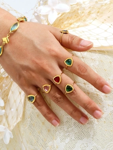 Detailweergave van 18K vergulde ringen met kleurrijke driehoekige kristallen op modelhanden